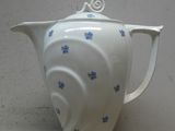 une théière blanche ornée de fleurs bleues