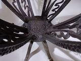 a metal sculpture of a dragonfly sitting on a white surface