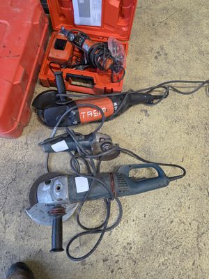 une boîte à outils rouge contenant des outils, posée par terre