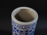 a blue and white vase sitting on a black surface