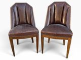 une paire de fauteuils en cuir marron avec des pieds en bois