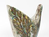 a white vase with a green and brown design on it