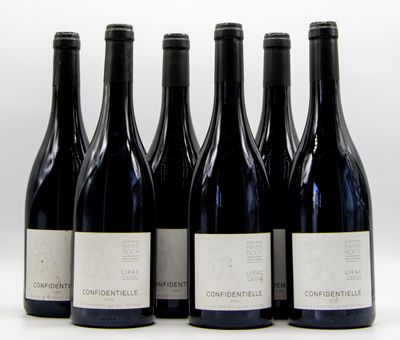 six bottles of wine are lined up in a row on a white surface