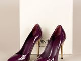 a pair of purple high heeled shoes in front of a box