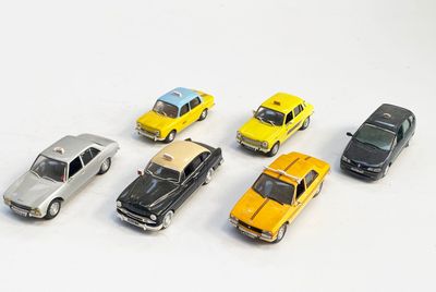 plusieurs petites voitures sont alignées sur une surface blanche