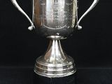 une image représentant un trophée argenté sur fond noir