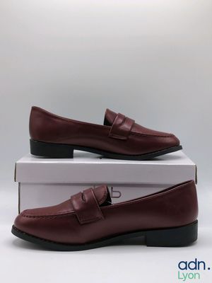 a pair of brown shoes sitting on top of a box