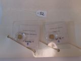 two pieces of gold coins in a clear box