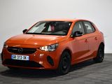 Une voiture orange est garée dans une pièce dont le sol est en damier.