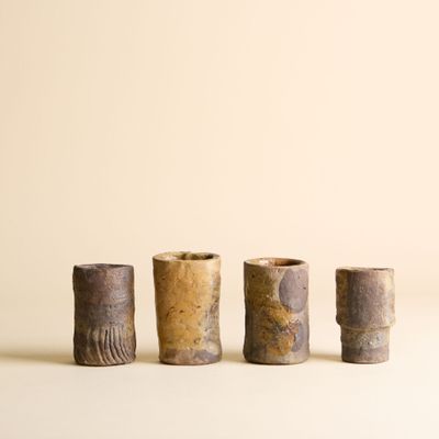 trois petits vases sont alignés sur une surface blanche