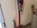 un aspirateur posé sur le sol à côté d'une poubelle