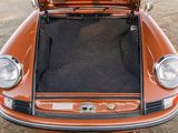 an orange car with its trunk open in a parking lot