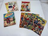 four vintage comic books on a white surface