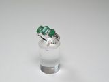 a close up of a ring with three emerald stones on it