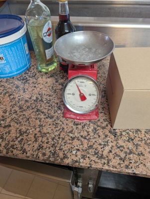un plan de travail de cuisine sur lequel se trouvent une balance et une boîte