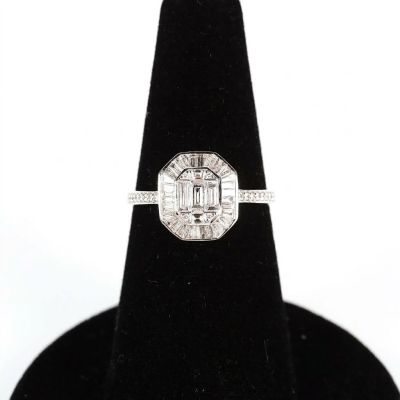un gros plan d'une bague en diamant posée sur un présentoir noir