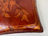 a brown leather box with a floral design on it