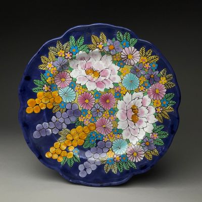 a blue plate with flowers and leaves on it