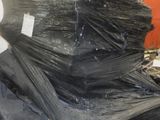 un gros tas de sacs en plastique noirs posé par terre