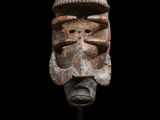 un masque en bois sur fond noir et un fond noir