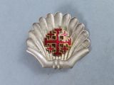 a silver shell with a red cross on it