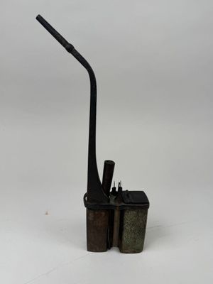 une pipe noire et deux briquets posés sur une surface blanche
