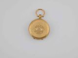 a small gold pocket watch with a chain on a white surface