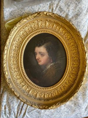tableau représentant un jeune homme, dans un cadre doré, posé sur une table