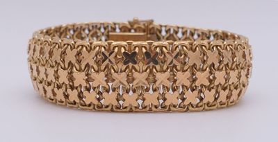 gros plan d'un bracelet en or sur une surface blanche