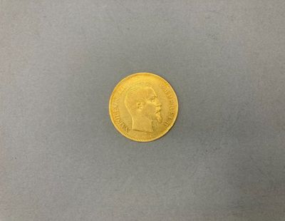 gros plan d'une pièce d'or sur une surface grise