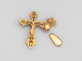 un gros plan d'une croix et d'un objet doré sur une surface blanche