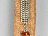 an image of a necklace with a picture of a man on it