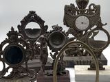 a lot of antique clocks that are sitting on a table