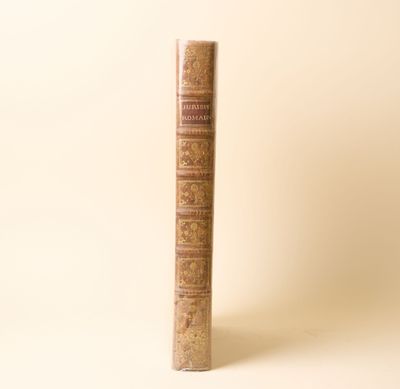 un vieux livre posé sur une table à côté d'un mur blanc
