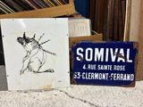 two signs sitting on the ground next to a pile of records