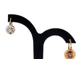 a close up of a pair of earrings on a stand