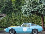 a blue sports car parked in front of a tree