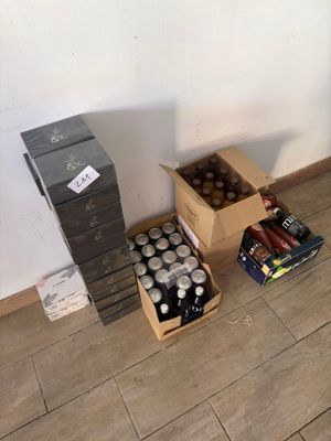 plusieurs cartons de sodas et de canettes posés par terre près d'un mur
