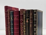 four books are lined up in a row on a white surface