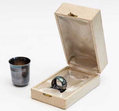 une bague dans une boîte en bois à côté d'une tasse