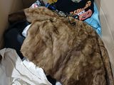 a cardboard box filled with clothes and a fur coat