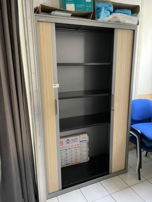 une chaise bleue posée devant une bibliothèque