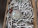 a box full of rope sitting on the ground next to a bottle