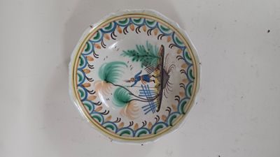 une petite assiette sur laquelle est représenté un oiseau, posée sur une table