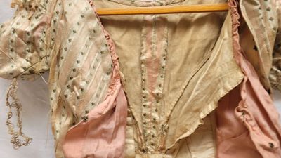 une robe sur un cintre accroché à un mur blanc