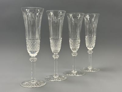 four clear wine glasses sitting next to each other on a table