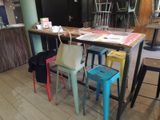 brightly colored stools sit in front of a wooden table in a restaurant