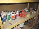 a shelf full of paint and other supplies on it