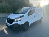 une camionnette blanche garée sur un parking avec des arbres en arrière-plan