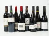 plusieurs bouteilles de vin sont alignées sur une surface blanche